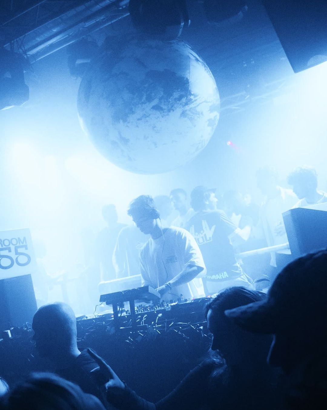 De echte opblaasbare BaseYRD-wereldbol boven de DJ-booth in blauw licht